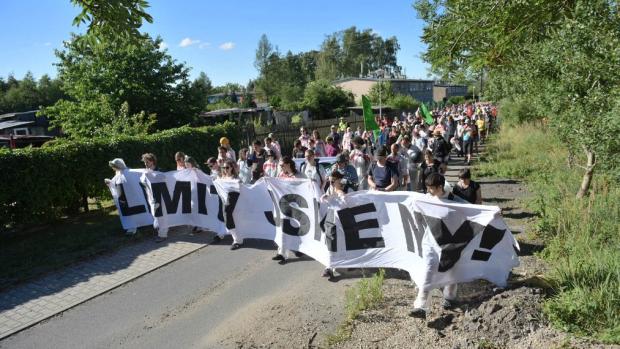 Skupina asi dvaceti lidí vylezla v sobotu ráno na vrchol rypadla v lomu Bílina a na místě se připoutali. Dalších několik stovek lidí vyrazilo na pochod proti těžbě uhlí.