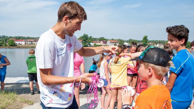 Bývalý moderní pětibojař David Svoboda předává dětem medaile po absolvování Olympijského běhu