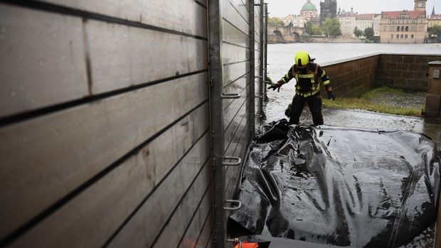 Hasič staví protipovodňové zábrany na Kampě v Praze