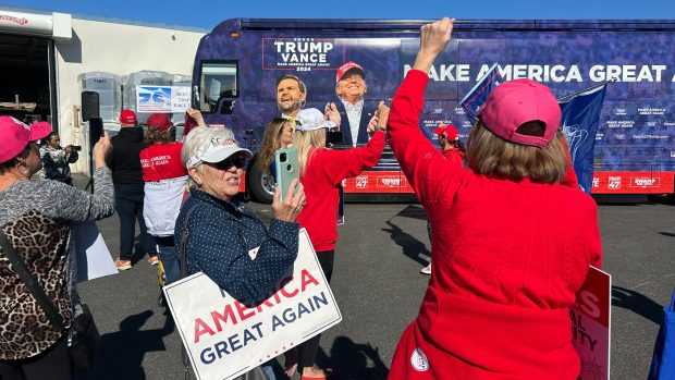 Trumpovi političtí podporovatelé u autobusu s velkou fotkou republikánského kandidáta Donalda Trumpa