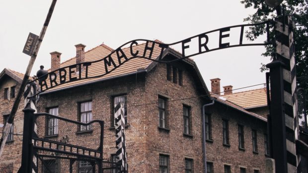 Vstup do Osvětimi: brána s nápisem Arbeit Macht Frei