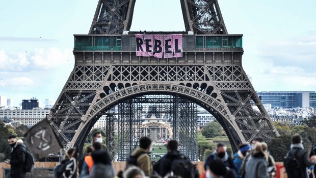 Příznivci hnutí Extinction Rebellion v neděli z Eiffelovy věže vyvěsili transparent s nápisem Rebel.