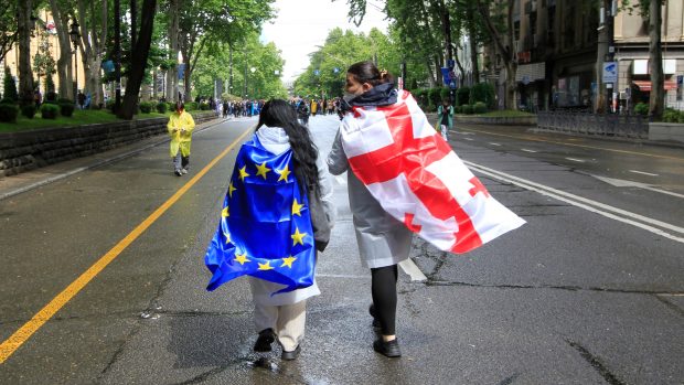 Gruzínské ženy s vlajkami Gruzie a Evropské unie se účastnily protestů proti přijetí zákona o zahraničním vlivu; parlament nakonec zákon přijal