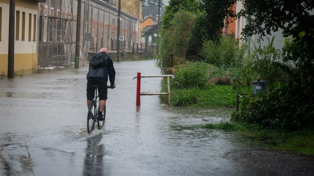 Zaplavená silnice ve městě Hejnice v neděli ráno