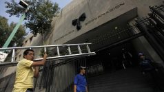 Dělníci odnášejí žebřík poté, co umístili na budovu mexickémho ministerstva vnitra černou stuhu jako symbol smutku za tragicky zahynulého ministra José Francisca Blaka