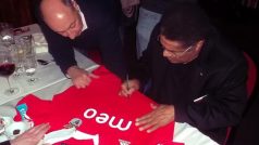 Eusébio za pomoci svého tajemníka podepisuje dres Benfiky, který půjde do dražby