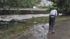 Lidé uklízejí po vydatných deštích, které zvedly hladiny některých toků. Životice u Nového Jičína. Květen 2014