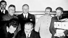 Molotov podepisuje německo-sovětskou smlouvu o neútočení. Za ním je vidět Ribbentrop (v černém) a Stalin (ve světlém, druhý zprava)