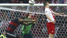 Polský útočník Milik překonává německého brankáře Neuera