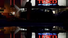 Zákazník vstupuje v Perivale v západním Londýně do prodejny Tesco, jejíž nápis se zrcadlí v kaluži