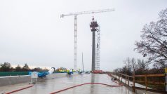 Stavbaři dobetonovali pylon nového mostu v Pardubicích. Bílé šikmo vycházející tubusy jsou připravené pro uchycení nosných lan v mostovce