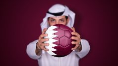 Arab držící fotbalový míč s katarskou vlajkou