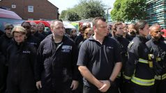 Zdravotníci a policisté během minuty ticha za oběti požáru v Grenfell Tower.