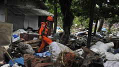 Záchranář prohledávající trosky po tsunami, která zpustošila indonéské pobřeží Sundského průlivu