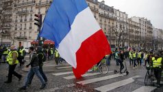 Demonstrant nese francouzskou vlajku při sobotním protestu žlutých vest v Paříži.