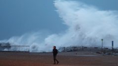 Muž na pobřeží Barcelony ve Španělsku sužovaném bouří Gloria.