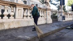 Pracovníci úklidové služby zametají sopečný popel z ulic blízkého města Katánie