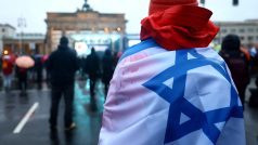 Muž s izraelskou vlajkou během protestu proti antisemitismu u Braniborské brány v Berlíně