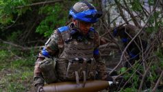 Příslušník Ukrajinské národní gardy nese náboj do houfnice D-20 při střelbě na ruské jednotky na frontové linii v Charkovské oblasti