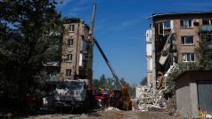 Záchranáři na místě, kde byl obytný dům v Kyjevě zasažen ruskou raketou