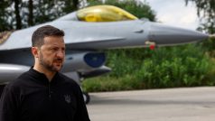 Ukrajinský prezident Volodymyr Zelenskyj hovoří s médii před bojovým letounem F-16 po oslavách Dne ukrajinského letectva uprostřed ruského útoku na Ukrajinu na neznámém místě na Ukrajině 4. srpna 2024