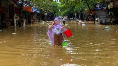 Žena se brodí zaplavenou ulicí ve městě Thai Nguyen ve Vietnamu. Kvůli supertajfunu Yagi zemřelo ve Vietnamu přes 140 lidí