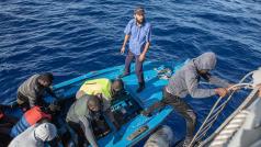 Migranti nastupují na loď libyjské pobřežní stráže.