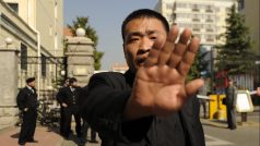Agent čínských bezpečnostních složek brání novináři ve focení domu, kde v domácím vězení žije Liou Sia (archivní snímek z roku 2013).