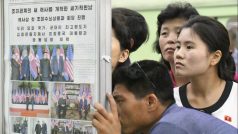 Obyvatelé severokorejské metropole si ve vestibulu metra pročítají stránky státních novin Rodong Sinmun. Donald Trump přijal Kim Čong-unovo pozvání k návštěvě Pchjongjangu, píše list ve svém vydání ze 13. června (den po summitu).