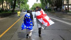 Gruzínské ženy s vlajkami Gruzie a Evropské unie se účastnily protestů proti přijetí zákona o zahraničním vlivu; parlament nakonec zákon přijal