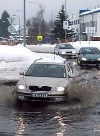 Auta v kalužích z tajícího sněhu