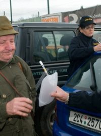 Policista kontroluje myslivce, zda nepožil před honem alkohol.