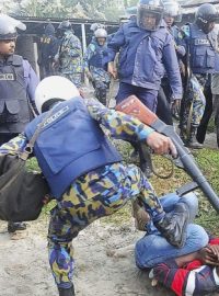 Volby v Bangladéši provázelo i násilí. Policista kope do aktivisty, který podpálil volební urnu