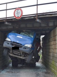 Kuriozní dopravní nehoda nákladního auta s bagrem