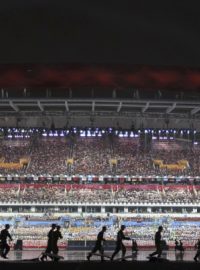 Čínští vojáci suší plochu stadionu během zahajovacího ceremoniálu olympijských her mládeže