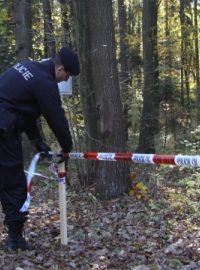 Policista upravuje pásku vymezující nepřístupný prostor v okolí muničního skladu ve Vrběticích na Zlínsku