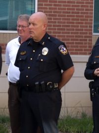 Policisté z města McKinney v Texasu včetně náčelníka Grega Conleyho (vpravo vpředu) naslouchají starostovi Brianu Loughmillerovi (snímek z videa)