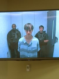 Američan Dylann Roof obviněný z devítinásobné vraždy v Charlestonu byl poprvé u soudu. Vyslechl ho přes videolink