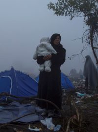 Žena s dítětem v improvizovaném táboře pro migranty poblíž srbsko-chorvatského hraničního přechodu Berkasovo (snímek z 22. října)