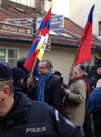 Poslanec TOP 09 Miroslav Kalousek s tibetskou vlajkou (vlevo) a europoslanec Jaromír Štětina s českou vlajkou se snaží projít skrz zástup policistů na protestní akci