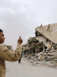 Chlapec si fotí zničené budovy v Palmýře