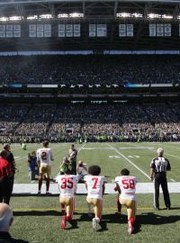 Hráč amerického fotbalu Colin Kaepernick (7) má zastání u spoluhráčů