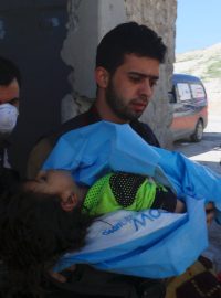 Muž nese tělo mrtvého dítěte po chemickém útoku v Idlibu