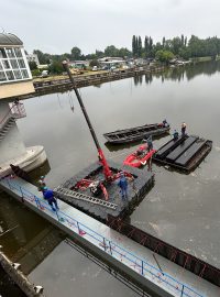 Jezové pole je nejdříve potřeba odvodnit. K tomu slouží stěna, kterou plovoucí jeřáb právě instaluje