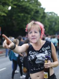Žena s maskou německé kancléřky Angely Merkelové během protestu před summitem G20 v Hamburku