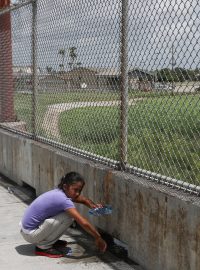 Dívka z Hondurasu čeká na mexické straně mezinárodního mostu Brownsville-Matamoros poté, co byl její rodině znemožněn vstup do USA.