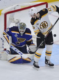 Brankář St. Louis Jordan Binnington chytá střelu útočníka Bostonu Bruins Charlieho Coylea