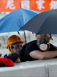 Protestující v centru Hongkongu se kryjí za rozevřenými deštníky