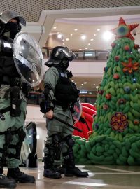 Policisté zasahují proti protivládním demonstrantům protestujícím na Štědrý den nákupním středisku v Hongkongu.