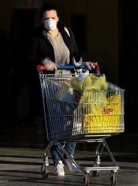 Žena opouští obchod s potravinami v Miláně.